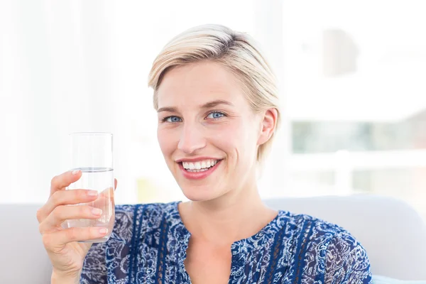 Blonde vrouw houden glas water — Stockfoto