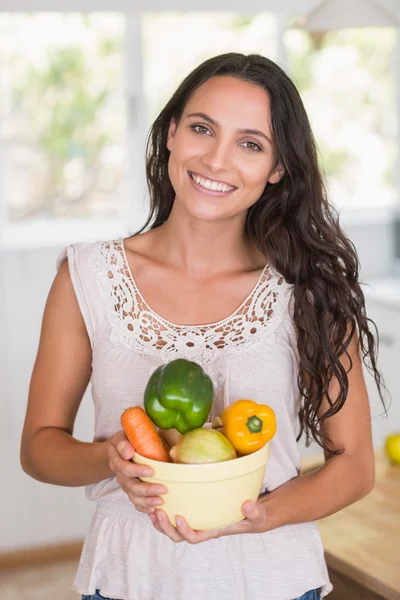 Beautiful brunette holding vegetables bowl — Stock Photo, Image