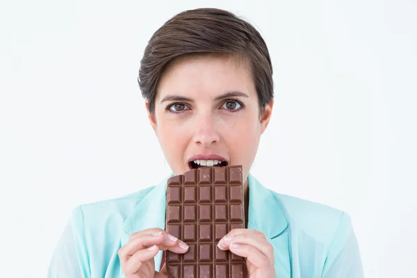 Brunette woman eating bar of chocolate — Stock Photo, Image