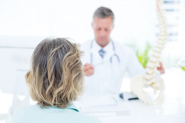 Doctor mostrando modelo de columna vertebral a su paciente —  Fotos de Stock