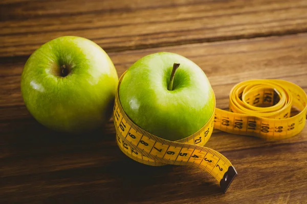 Green apples with measuring tape — Stock Photo, Image