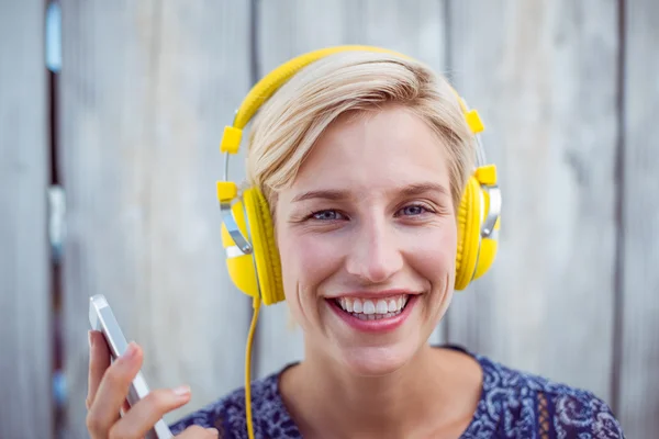Vrouw luisteren muziek met mobiele telefoon — Stockfoto