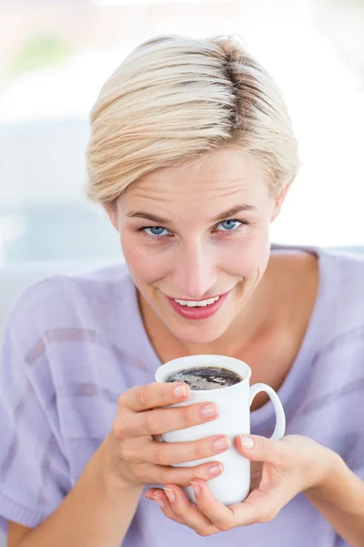 Mulher loira no sofá segurando uma caneca — Fotografia de Stock