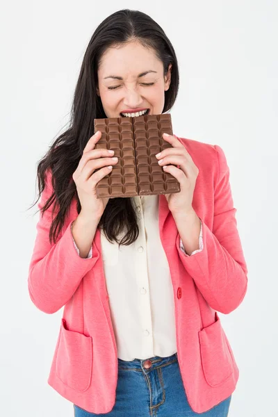 Brunette biting bar of chocolate — Stock Photo, Image