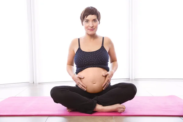 Беременная женщина в форме — стоковое фото