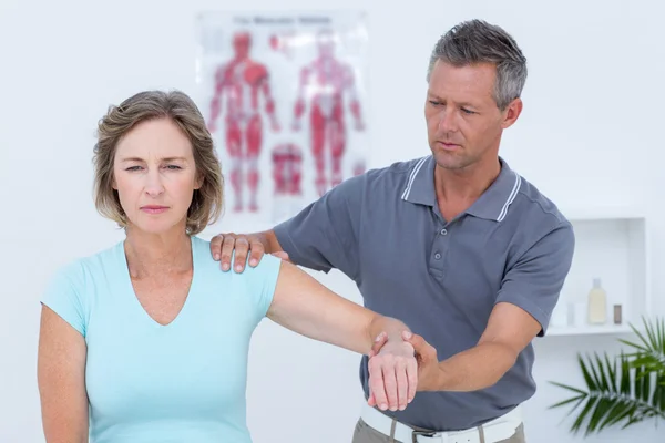 Doctor examinando su brazo paciente — Foto de Stock