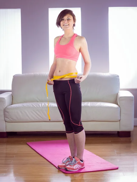 Portrait of happy slim woman measuring waist — Stock Photo, Image