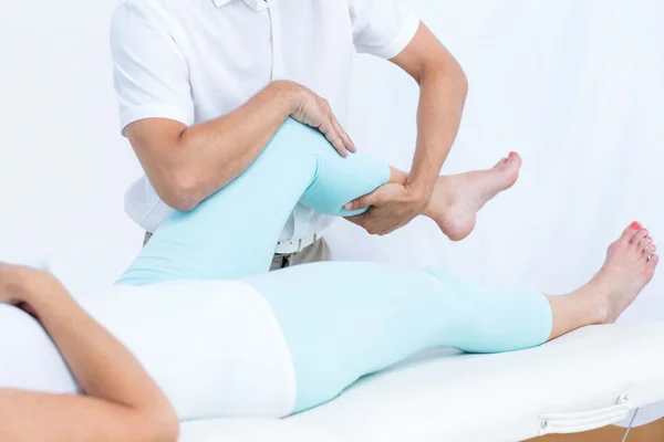 Fisioterapeuta fazendo massagem nas pernas de seu paciente — Fotografia de Stock