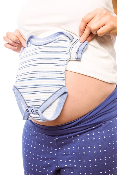 Mulher grávida segurando roupas de bebê — Fotografia de Stock