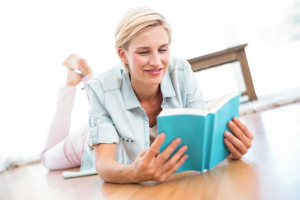 Blonde woman on the floor reading a book — Stock Photo, Image