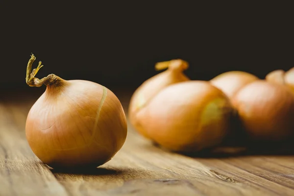 Frische Zwiebeln auf Holzgrund — Stockfoto