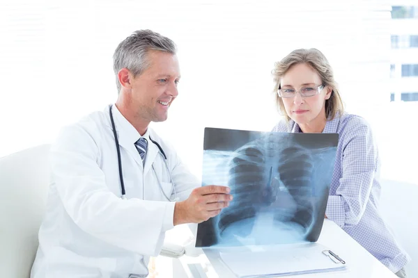 Läkare visar xray att hans patient — Stockfoto