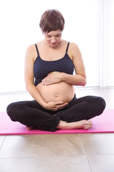 Zwangere vrouw houden in vorm — Stockfoto