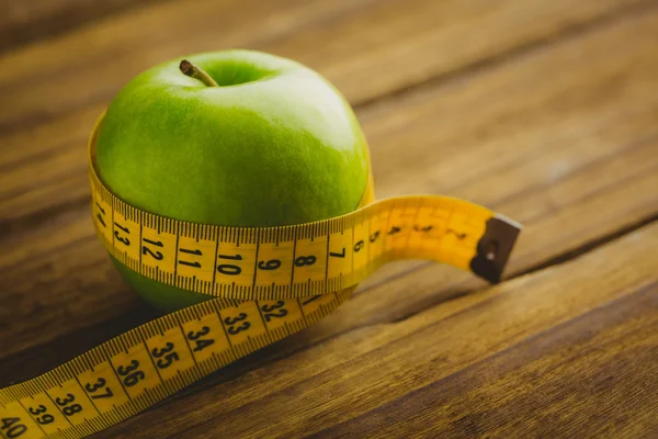 Green apple with measuring tape — Stock Photo, Image