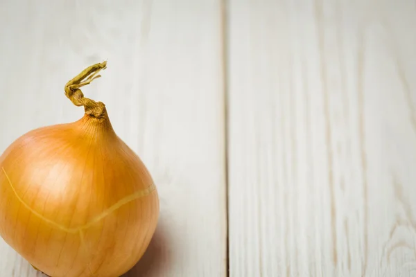 Frische Zwiebel auf hölzernem Hintergrund — Stockfoto