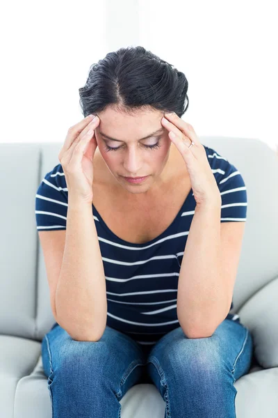 Unhappy woman sitting on the couch — Stock Photo, Image