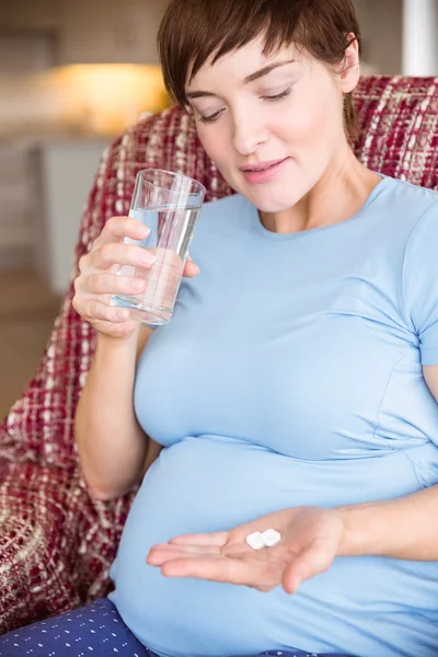 Kobieta w ciąży biorąc tabletkę witaminy — Zdjęcie stockowe