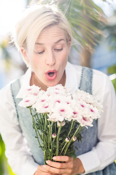 Mulher loira segurando monte de flores — Fotografia de Stock