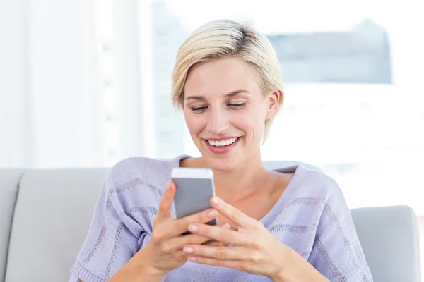 Mujer rubia mensajes de texto con teléfono móvil — Foto de Stock