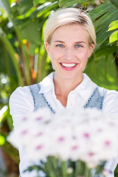 Blonde woman holding bunch of flowers — Stock Photo, Image
