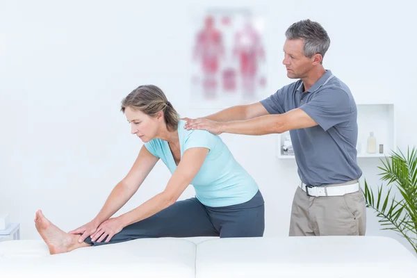 Fisioterapista aiutare il suo paziente stretching — Foto Stock