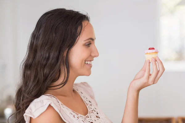 Beautiful brunette holding mini cupcake — Stock Photo, Image