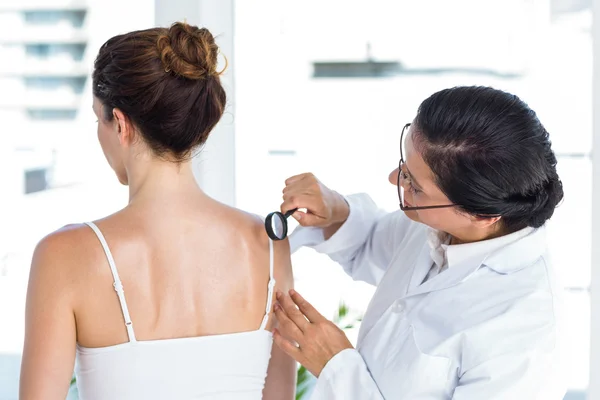 Médico examinando paciente com lupa — Fotografia de Stock