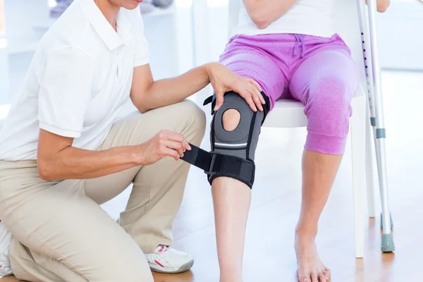 Doctor examining her patients knee — Stock Photo, Image