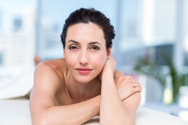 Smiling brunette relaxing on massage table — Stock Photo, Image