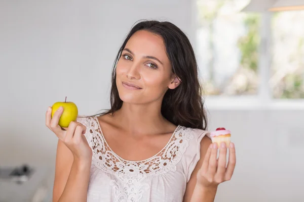 Vacker brunett holding mini cupcake — Stockfoto