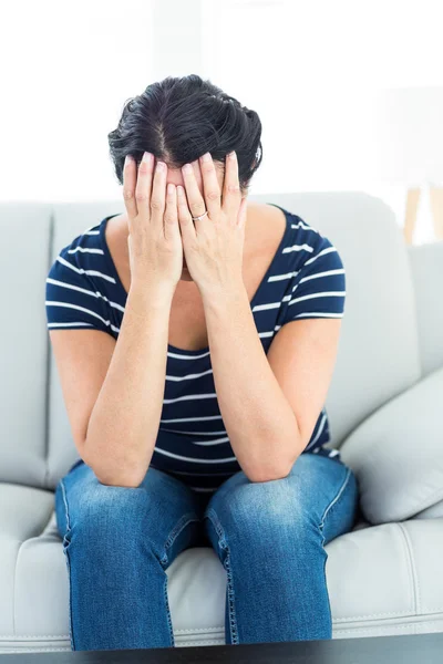 Unhappy woman sitting on the couch — Stock Photo, Image