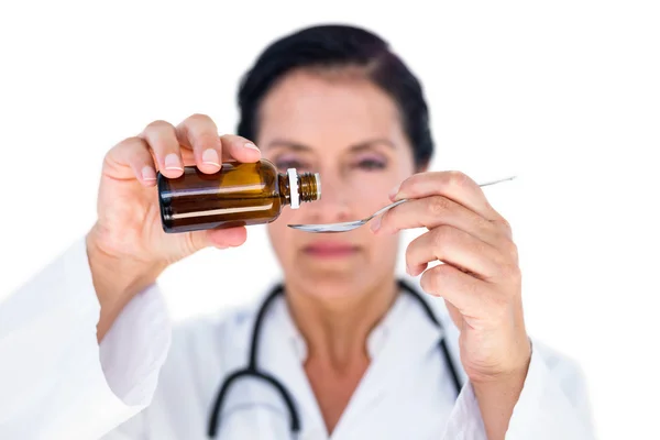 Женщина-врач наливает сироп в ложку — стоковое фото