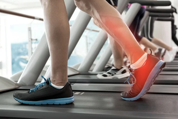Highlighted ankle of man on treadmill — Stock Photo, Image