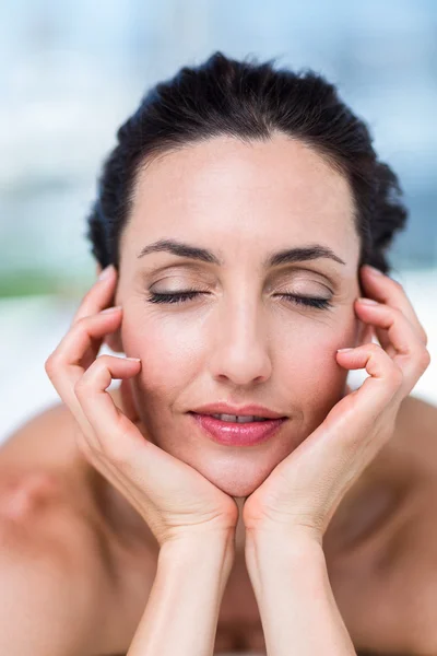 Lächelnde Brünette entspannt sich auf Massagetisch — Stockfoto