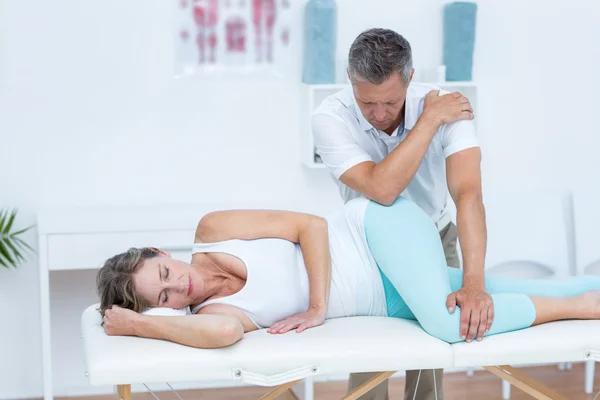 Arts zijn patiënt heup masseren — Stockfoto
