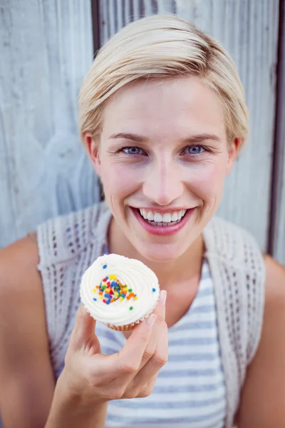 Söt blond kvinna anläggning cupcake — Stockfoto