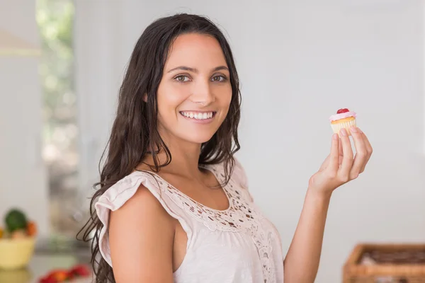 Vacker brunett holding mini cupcake — Stockfoto