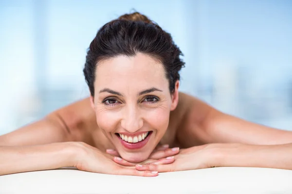 Smiling brunette relaxing on massage table — Stock Photo, Image