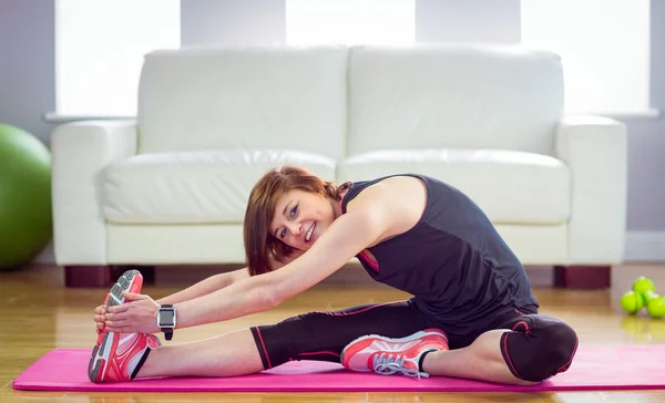 Vältränad kvinna stretching på träningsmatta — Stockfoto