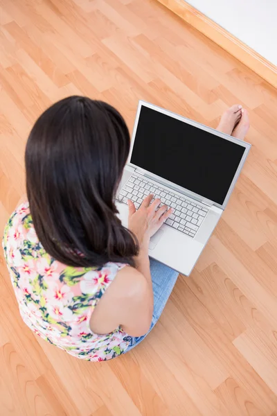 Ładna brunetka za pomocą laptopa na podłodze — Zdjęcie stockowe