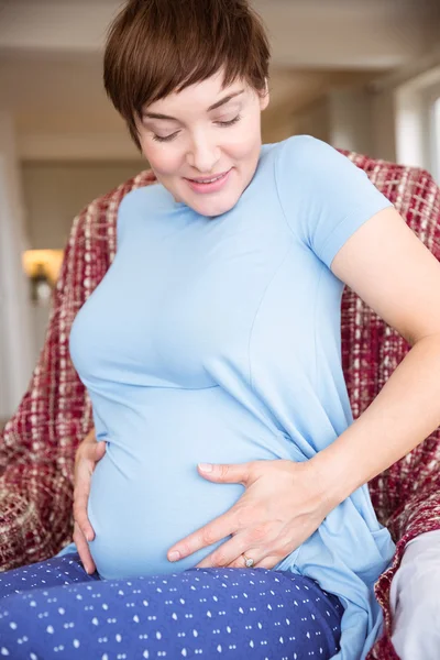 怀孕的女人正看着她的肚子 — 图库照片