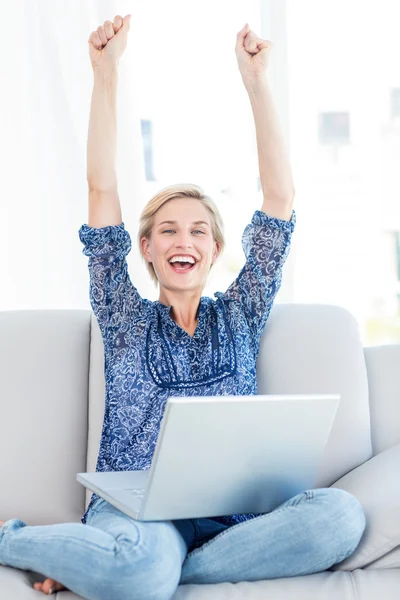 Hübsche blonde Frau jubelt auf der Couch — Stockfoto