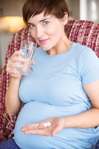 Mujer embarazada que toma un comprimido vitamínico — Foto de Stock