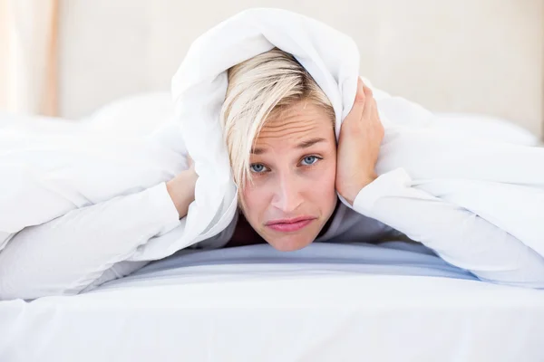 Sconvolto donna bionda sdraiata sul letto — Foto Stock