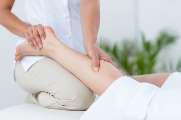 Fisioterapeuta fazendo massagem nas pernas — Fotografia de Stock