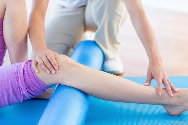 Trainer met vrouw bezig met oefening mat — Stockfoto