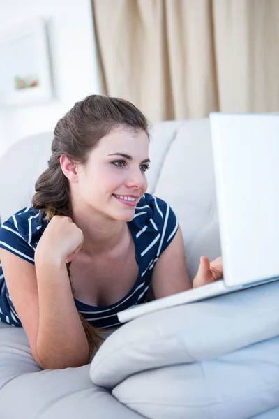 Brunette op Bank met behulp van haar laptop — Stockfoto