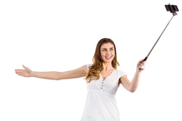 Pretty woman using a selfie stick — Stock Photo, Image