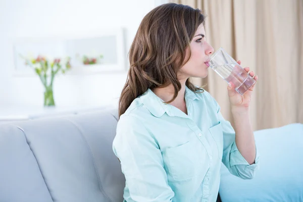 Eftertänksam kvinna dricka ett glas vatten — Stockfoto