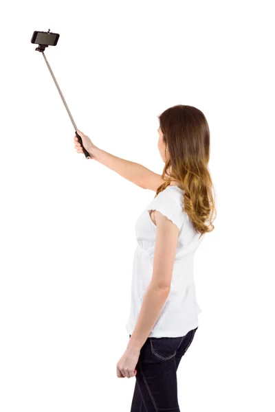 Jolie femme utilisant un selfie stick — Photo